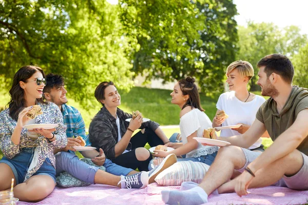 Glada vänner äta smörgåsar på sommar picknick — Stockfoto