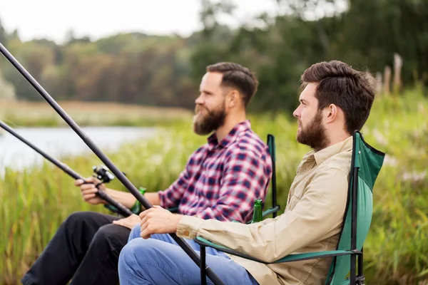 Amigos masculinos com varas de pesca no lago — Fotografia de Stock