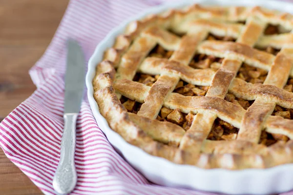 Close up of apple pie in baking mold and knife — Stock Photo, Image