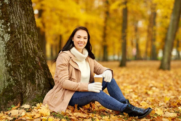 Frau trinkt Kaffee zum Mitnehmen im Herbstpark — Stockfoto