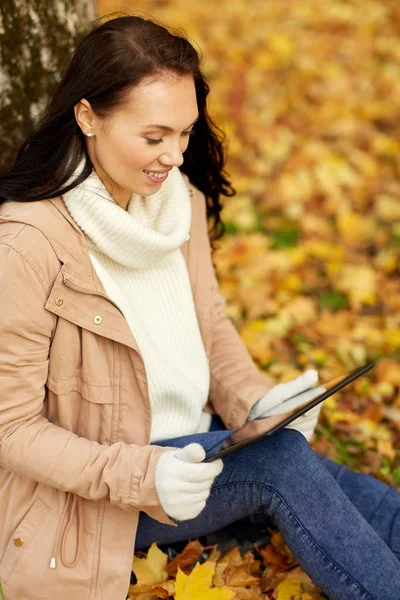 Donna con tablet al parco autunnale — Foto Stock