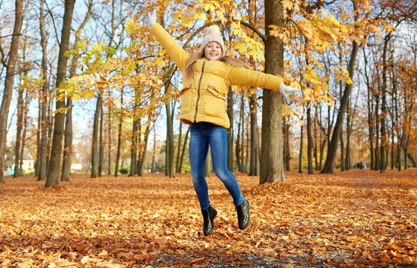 Fille heureuse sautant au parc d'automne — Photo