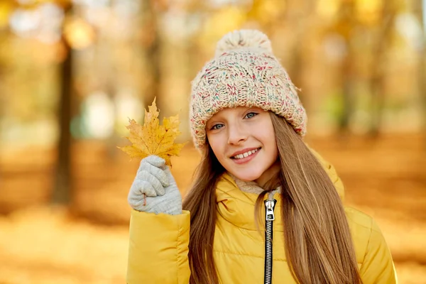 Portrait of girl with maple leaf at autumn park — Stock Photo, Image