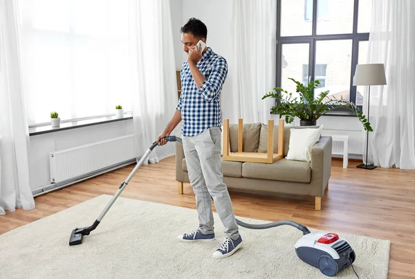 Pria dengan vacuum cleaner menelepon di rumah — Stok Foto