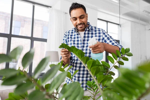 Man spuitende kamerplant met water thuis — Stockfoto