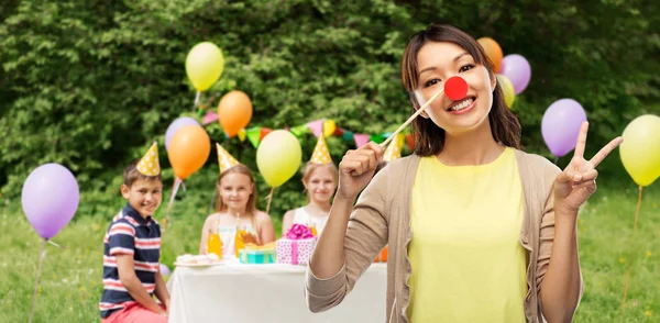 Kobieta z clown nos na urodziny dzieci — Zdjęcie stockowe