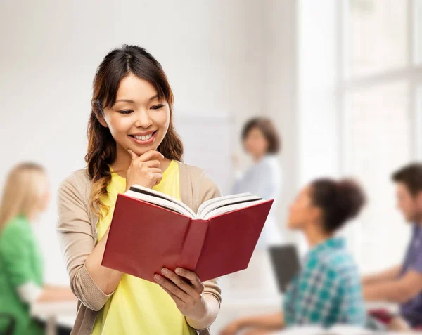 Lycklig asiatisk kvinna Läs bok i skolan — Stockfoto