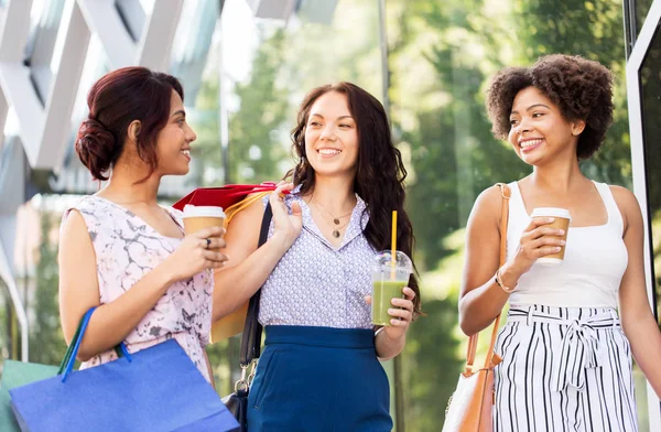 Femmes avec sacs à provisions et boissons dans la rue de la ville — Photo