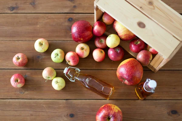 Botellas de zumo de manzana o vinagre sobre mesa de madera —  Fotos de Stock