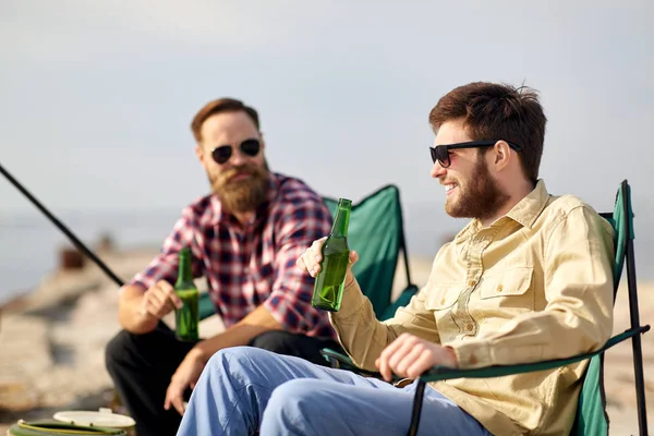Mutlu arkadaşlar balık tutuyor ve iskelede bira içiyor. — Stok fotoğraf