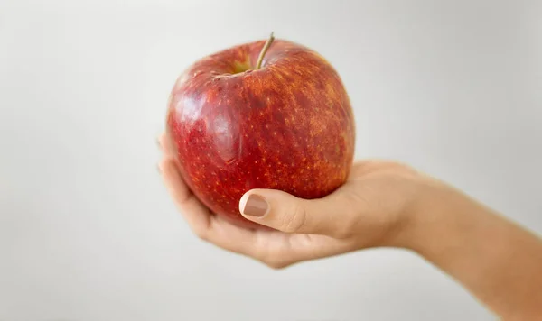 Zbliżenie rąk trzymających dojrzałe czerwone jabłko — Zdjęcie stockowe