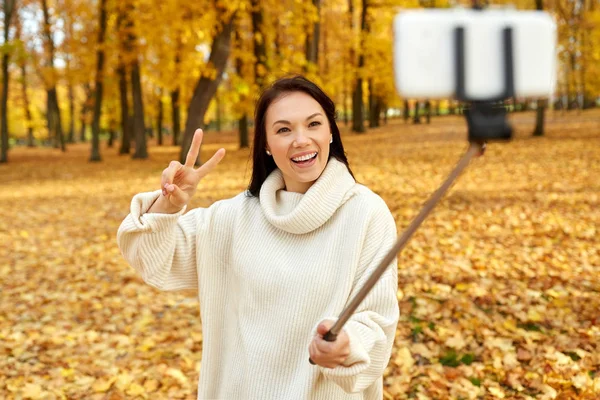 Woman taking selfie by smartphone at autumn park — Stock Photo, Image