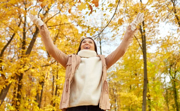Mujer feliz divirtiéndose con hojas en el parque de otoño — Foto de Stock