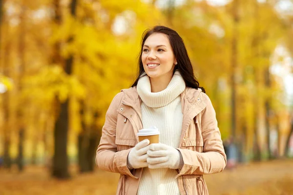 Frau trinkt Kaffee zum Mitnehmen im Herbstpark — Stockfoto