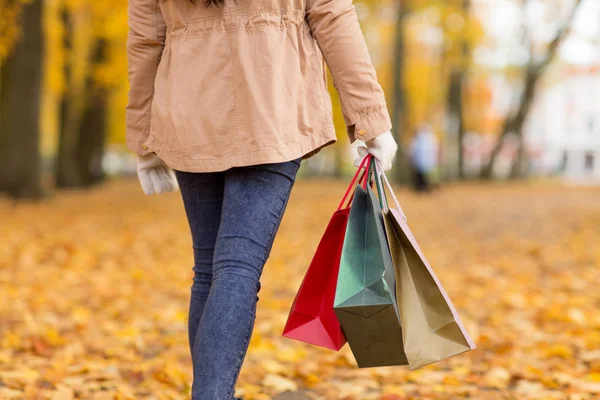 秋の公園を歩いての買い物袋を持つ女性 — ストック写真