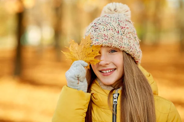 Portrait of girl with maple leaf at autumn park — Stock Photo, Image