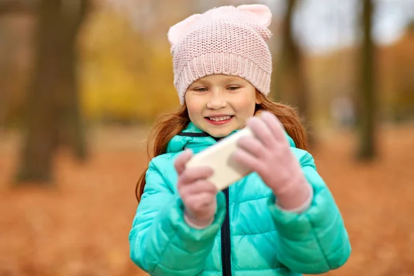 Κορίτσι με smartphone στο πάρκο φθινόπωρο — Φωτογραφία Αρχείου