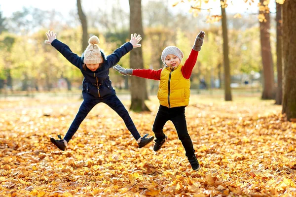 Glückliche Kinder laufen im Herbstpark — Stockfoto