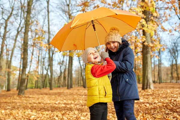 Szczęśliwy dzieci z parasolem w jesiennym parku Obraz Stockowy
