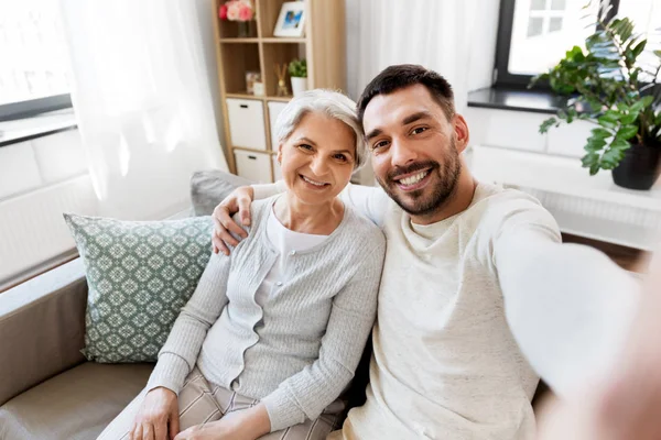 Senior moeder met volwassen zoon nemen selfie thuis — Stockfoto