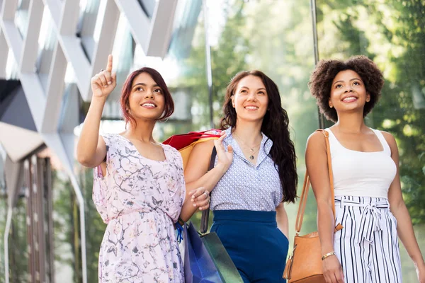 Gelukkig vrouwen met boodschappentassen in stad — Stockfoto