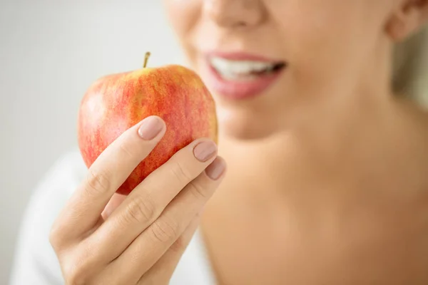Крупным планом женщина, держащая в руках спелое красное яблоко — стоковое фото