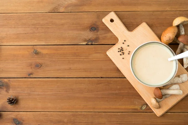 Mushroom cream soup in bowl on cutting board — Stock Photo, Image