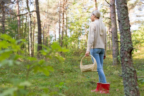 秋の森でキノコ狩りをしている若い女性 — ストック写真