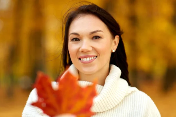 Heureuse jeune femme avec feuille d'érable dans le parc d'automne — Photo