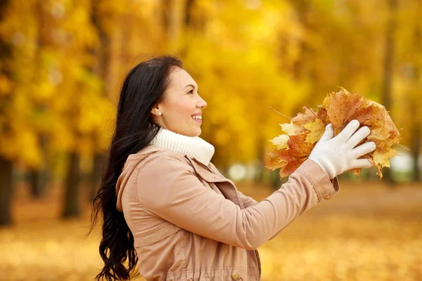 Happy woman having fun with leaves in autumn park — Stock Photo, Image