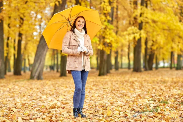 Gelukkig vrouw met paraplu in herfst park — Stockfoto