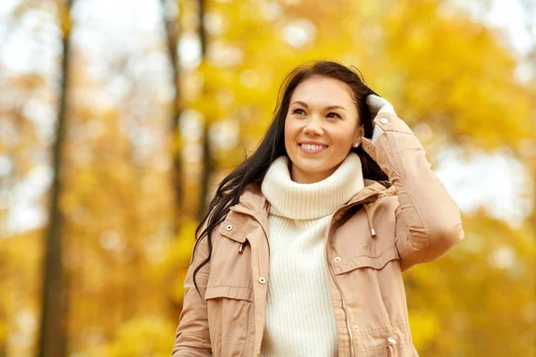 Krásná šťastná mladá žena s úsměvem na podzim park — Stock fotografie