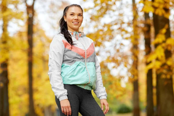 Giovane donna in abbigliamento sportivo al parco autunnale — Foto Stock