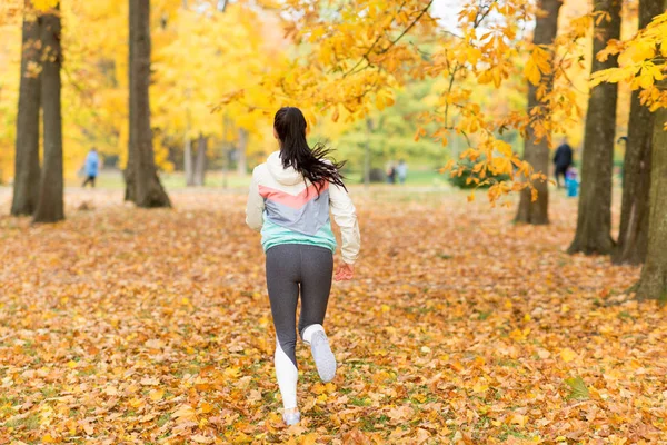 秋の公園を走る若い女性は — ストック写真