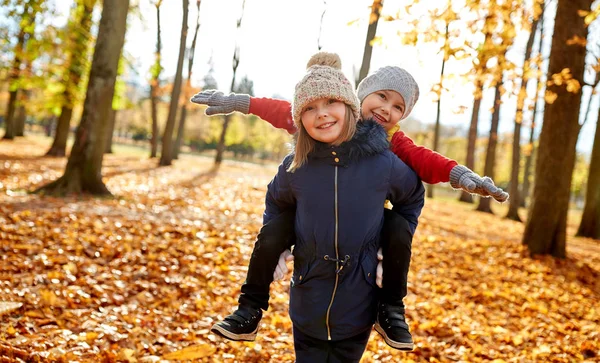 Niños felices divirtiéndose en el parque de otoño —  Fotos de Stock