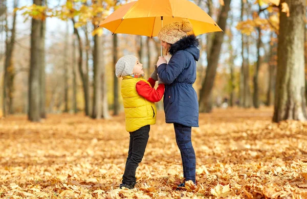 Gelukkige kinderen met parasol in het najaarspark — Stockfoto