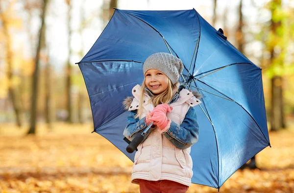 Szczęśliwa dziewczynka z parasolem w jesiennym parku — Zdjęcie stockowe