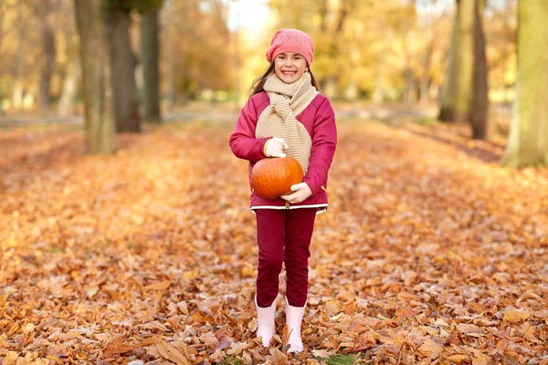 Happy girl with pumpkin at autumn park — Stock Photo, Image