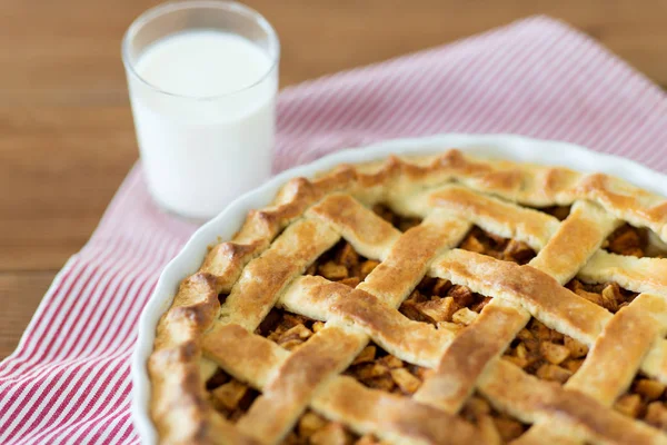 Tarte aux pommes en moule de cuisson et verre de lait — Photo