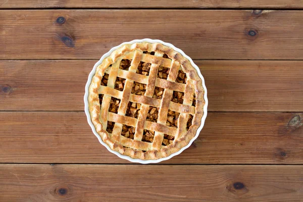 Close up of apple pie in mold on wooden table — Stock Photo, Image