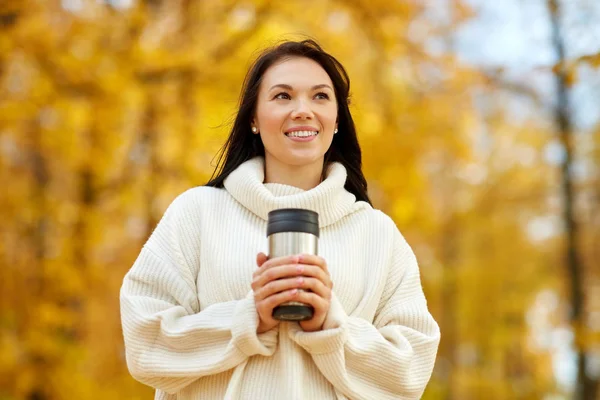 Mujer con bebida caliente en vaso en el parque de otoño —  Fotos de Stock