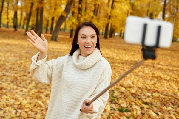 Kvinna som tar selfie via smartphone i höstparken — Stockfoto