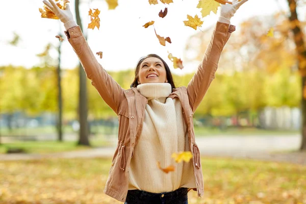 Femme heureuse s'amuser avec des feuilles dans le parc d'automne — Photo