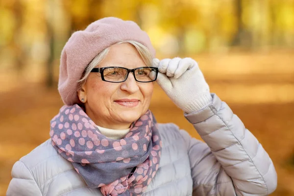 Portret van een vrolijke oudere vrouw in het herfstpark — Stockfoto