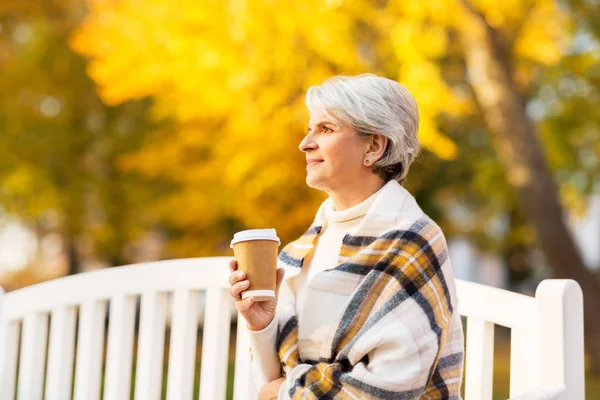 Femeia în vârstă bea cafea în parcul de toamnă — Fotografie, imagine de stoc