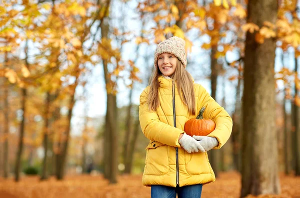 Menina feliz com abóbora no parque de outono — Fotografia de Stock