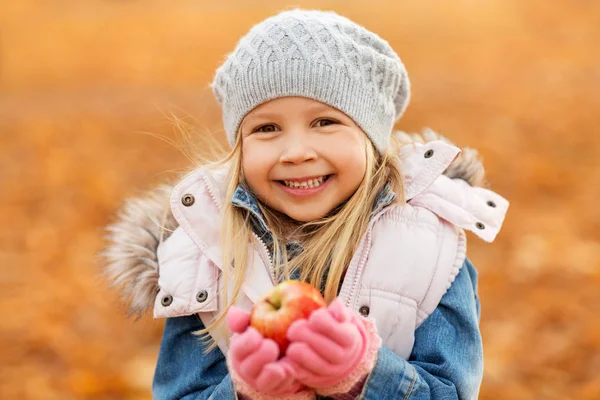 Portrait of happy little girl with apple in autumn — Stock Photo, Image