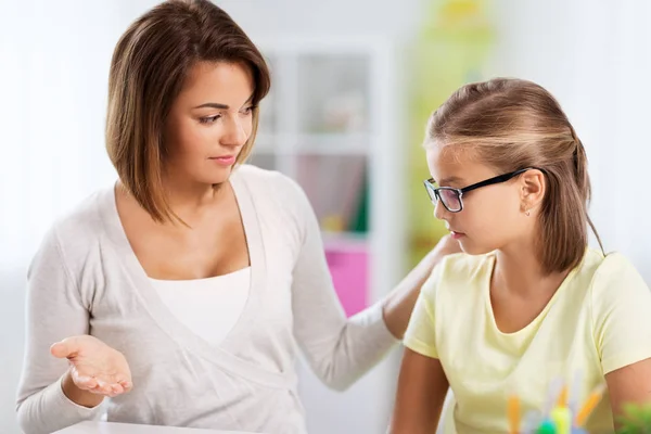 Расстроена мать разговаривает с дочерью делает домашнее задание — стоковое фото