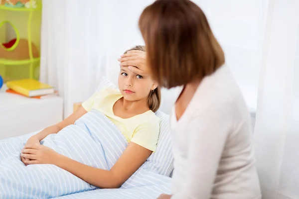 Mother taking care of unhealthy daughter at home — Stock Photo, Image