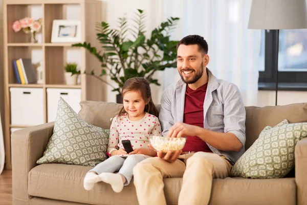 Lycklig far och dotter titta på tv hemma — Stockfoto